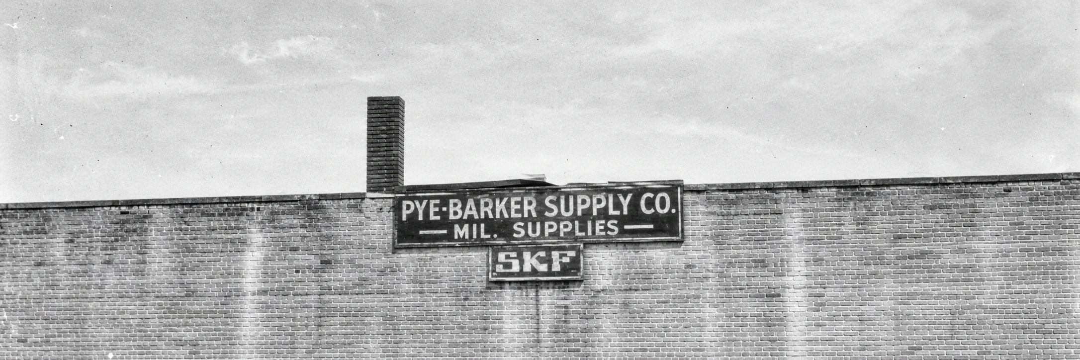 Archival black-and-white photo of the Pye-Barker Supply Co. sign on a brick building